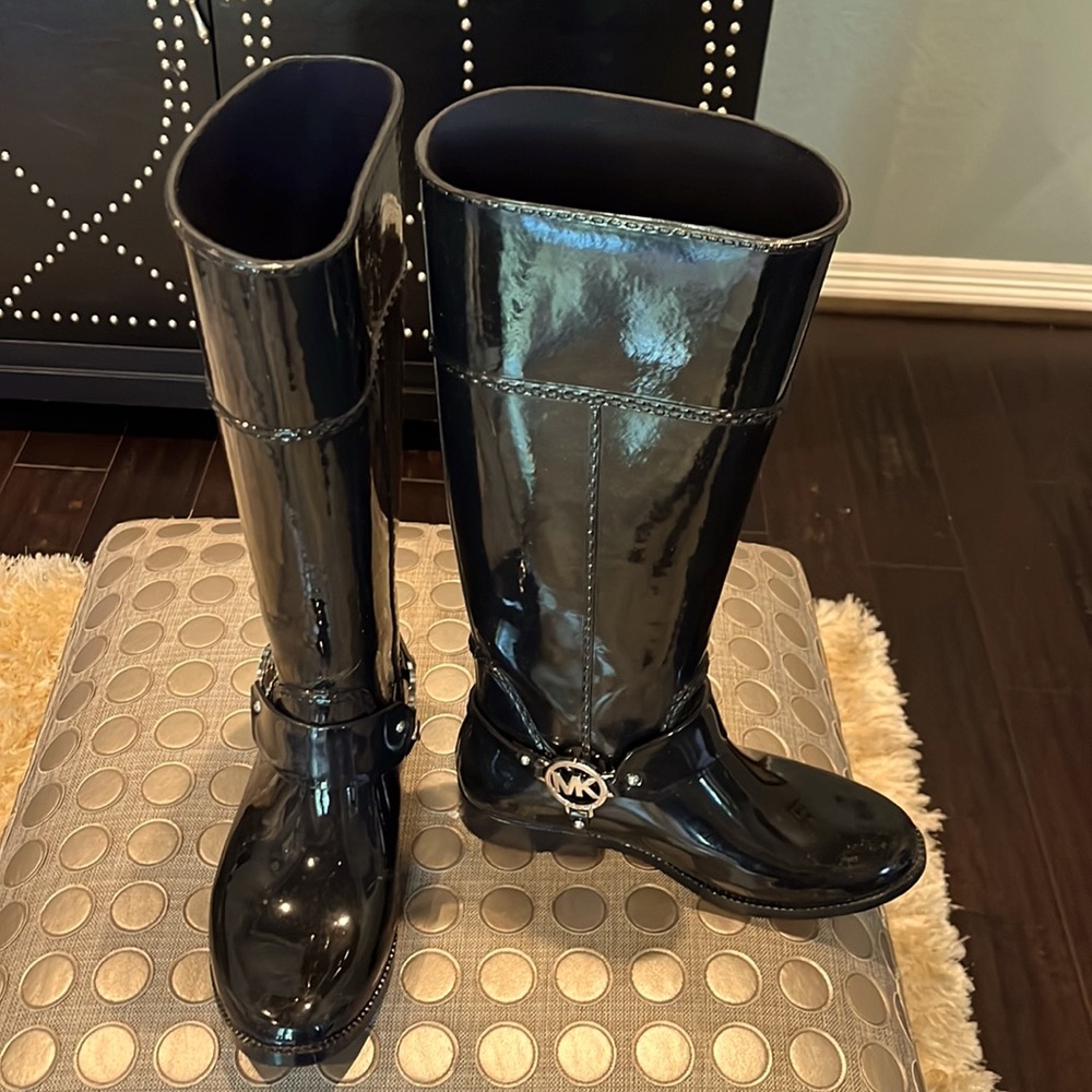 Black patent leather tall shaft rain boots.